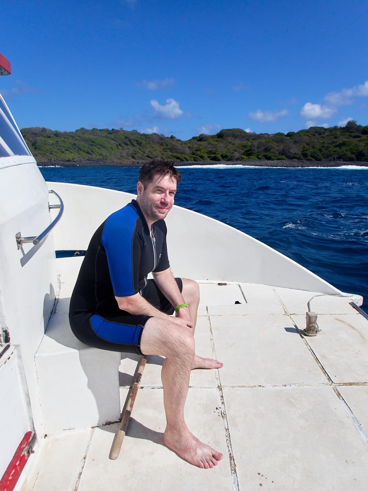 Me in a wetsuit, sitting aboard the dive boat after scuba diving for the first